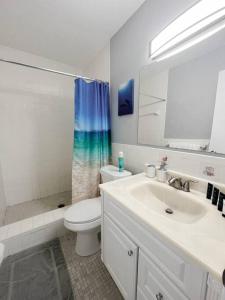 a bathroom with a sink and a toilet and a shower at Beautiful 2 Bed Beach Condo With DOCK - Walk Everywhere! in St. Pete Beach