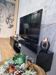 ein Wohnzimmer mit einem TV und einem verzierten Tisch in der Unterkunft Marilyn Lux Apartment in Skopje