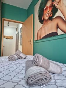 een bed met handdoeken en een foto van een vrouw bij Marilyn Lux Apartment in Skopje