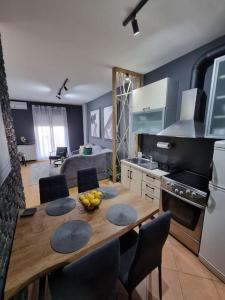 eine Küche mit einem Holztisch mit Stühlen und einem Esszimmer in der Unterkunft Marilyn Lux Apartment in Skopje
