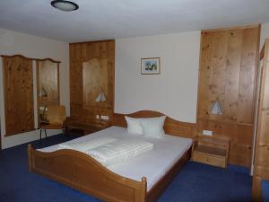 Schlafzimmer mit einem großen Bett und Holzwänden in der Unterkunft Köflerhof Appartements in Sankt Leonhard im Pitztal