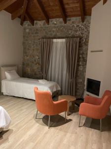 1 dormitorio con 1 cama, 2 sillas y TV en Miltilon en Synikia Mesi Trikalon