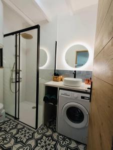 a bathroom with a washing machine and a shower at Gîte Mas Provençal Piscine Parking Privé L'Isle-Sur-La-Sorgue in LʼIsle-sur-la-Sorgue