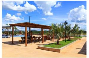 Praias do Lago Eco Resort 1 quarto في كالدس نوفاس: جناح مع طاولة وكراسي ومسبح