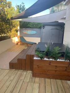 eine Terrasse mit einer Holzterrasse mit Pflanzen in der Unterkunft Logement F3 moderne, un petit paradis a Paris ! in Le Plessis-Robinson