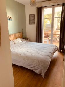 Schlafzimmer mit einem Bett und einer Glasschiebetür in der Unterkunft Logement F3 moderne, un petit paradis a Paris ! in Le Plessis-Robinson