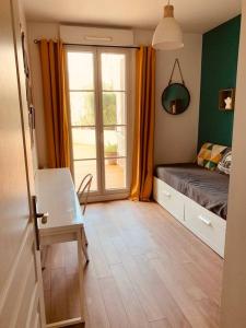 ein kleines Schlafzimmer mit einem Bett und einem Fenster in der Unterkunft Logement F3 moderne, un petit paradis a Paris ! in Le Plessis-Robinson