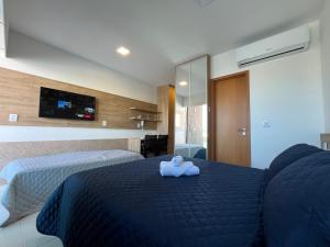a bedroom with a bed with a stuffed animal on it at Makia Flat Muro Alto in Porto De Galinhas