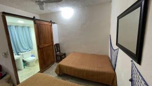 a small room with two beds and a mirror at Casa bugambilias in Troncones