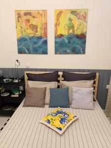 Gemütliches Appartement in Ano Poli في سلانيك: غرفة نوم مع سرير مع لوحتين على الحائط