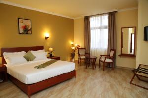 um quarto de hotel com uma cama, uma mesa e cadeiras em Ye Afoli International Hotel em Addis Ababa