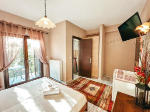 um quarto com uma cama, uma mesa e uma janela em Filimon GuestHouse Villa em Xanthi