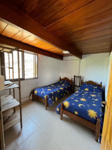1 dormitorio con 2 camas y techo de madera en EL CHALÉ casa de campo en Mina Clavero