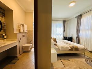 a bedroom with a bed and a bathroom with a sink at Westwood Residences in Arusha