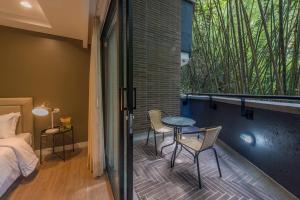 a room with a balcony with a bed and a table and chairs at El Tesoro Medellín Hab315 by Letoh in Medellín