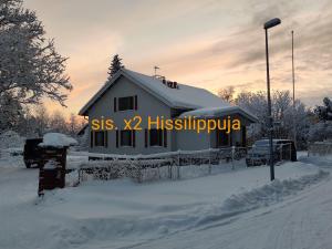 a house covered in snow with the words sss x histivivo at Nina`s GuestHouse, 30m2, 75m2 ja 85m2 tai koko talo 190m2 in Jämsä