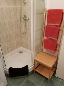 y baño con ducha, toallas rojas y mesa. en Hirondelle de Rouen, en Rouen