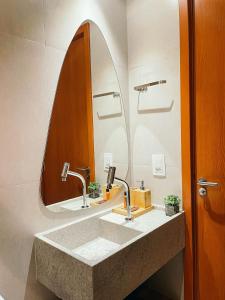 une salle de bain avec un lavabo et un miroir dans l'établissement Excelente condomínio com uma belíssima área de lazer próximo à praia do Patacho, à Porto de Pedras