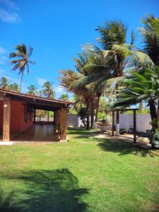 a house with palm trees in a yard at Perobas beach house in Touros