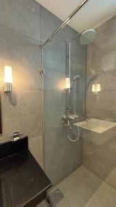 a bathroom with a glass shower with a sink at Apartment314 Oceanfront condos Nilaveli in Trincomalee
