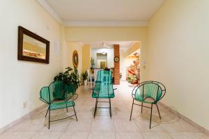 a hallway with green chairs and a dining room at Hostal Cartagonova - Habitaciones privadas y amplias cerca a zonas turísticas in Cartagena de Indias