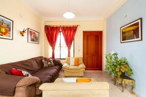 sala de estar con sofá y silla en Hostal Cartagonova - Habitaciones privadas y amplias cerca a zonas turísticas, en Cartagena de Indias