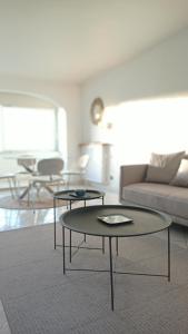 a living room with two tables and a couch at BLEU CASSIS-VINTAGE -3 Ch- Magnifique vue mer- Parking gratuit et Jardin in Cassis