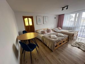 斯洛莫夫采維茲納的住宿－Pod Skałką，卧室配有一张床和一张桌子及椅子