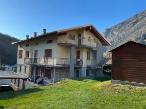 a large house with a balcony and a table at L'Acero Rosso in Prosto di Piuro