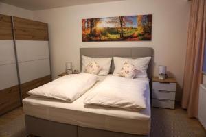 - une chambre avec un lit doté de draps et d'oreillers blancs dans l'établissement Haus Walser, à Tarrenz