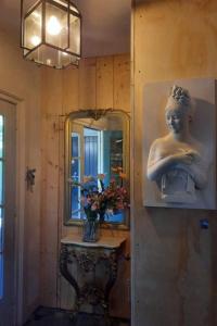 een kamer met een spiegel en een standbeeld aan de muur bij Eesergroen aan zee in Eesergroen