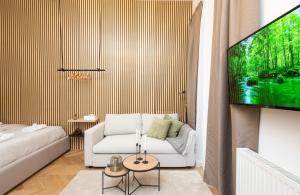 ein Wohnzimmer mit einem weißen Sofa und einem Flachbild-TV in der Unterkunft Charming retreat near town centre in Wien