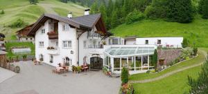 an aerial view of a large white house with a patio at B&B Appartments Cudlea in Selva di Val Gardena