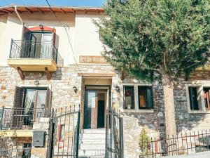 een stenen gebouw met een boom ervoor bij Filimon GuestHouse Villa in Xanthi