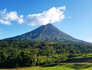 a mountain in the middle of a field with trees at Casa Gamboa, La Fortuna in Fortuna