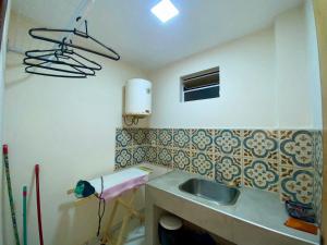 uma pequena cozinha com um lavatório e um lavatório em Agradable dormitorio en suite con estacionamiento privado em Ciudad del Este