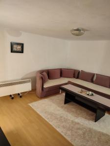 ein Wohnzimmer mit einem Sofa und einem Tisch in der Unterkunft Topli kutak Banja Luka in Banja Luka