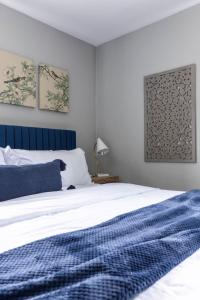 um quarto com uma cama com uma cabeceira azul em Westlake Elegance - Detroit Unit 3 em Westlake