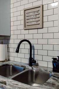 um lavatório numa cozinha com uma placa na parede em Westlake Elegance - Detroit Unit 3 em Westlake