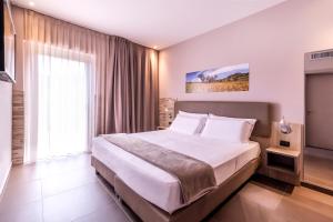 um quarto com uma cama grande e uma janela grande em San Giorgio Palace Hotel Ragusa Ibla em Ragusa