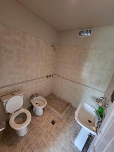 a bathroom with a toilet and a bidet and a sink at Las Pircas 182 in San Salvador de Jujuy