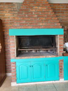 a blue cabinet in front of a brick fireplace at Las Pircas 182 in San Salvador de Jujuy