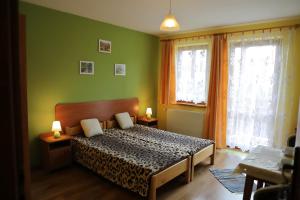 1 dormitorio con 1 cama con paredes verdes y 2 ventanas en U Mikołajczyków, en Szczawnica
