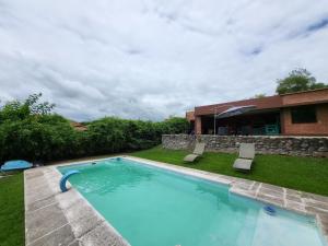 a swimming pool in a yard next to a house at Las Pircas 182 in San Salvador de Jujuy