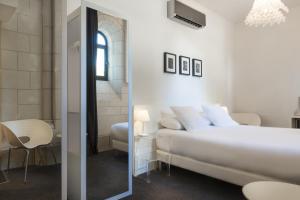 a white bedroom with a bed and a mirror at SOZO Hotel in Nantes