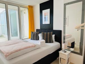 ein Schlafzimmer mit einem Bett und einem großen Fenster in der Unterkunft Strand-Penthouse, 128 qm, Maisonette, Parkplatz in Wilhelmshaven