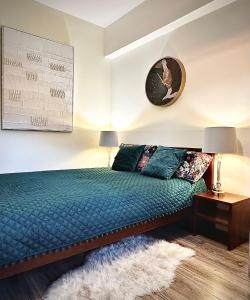 um quarto com uma cama verde e um tapete em Apartament przy Bulwarach em Krynica-Zdrój