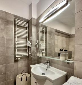 uma casa de banho com um lavatório e um espelho em Apartament przy Bulwarach em Krynica-Zdrój