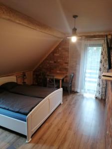 1 dormitorio con 1 cama y suelo de madera en Pokoje 64, en Ustroń