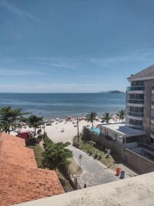 uma vista para uma praia com um edifício e o oceano em Cobertura frente ao mar Lexus Plaza em Florianópolis